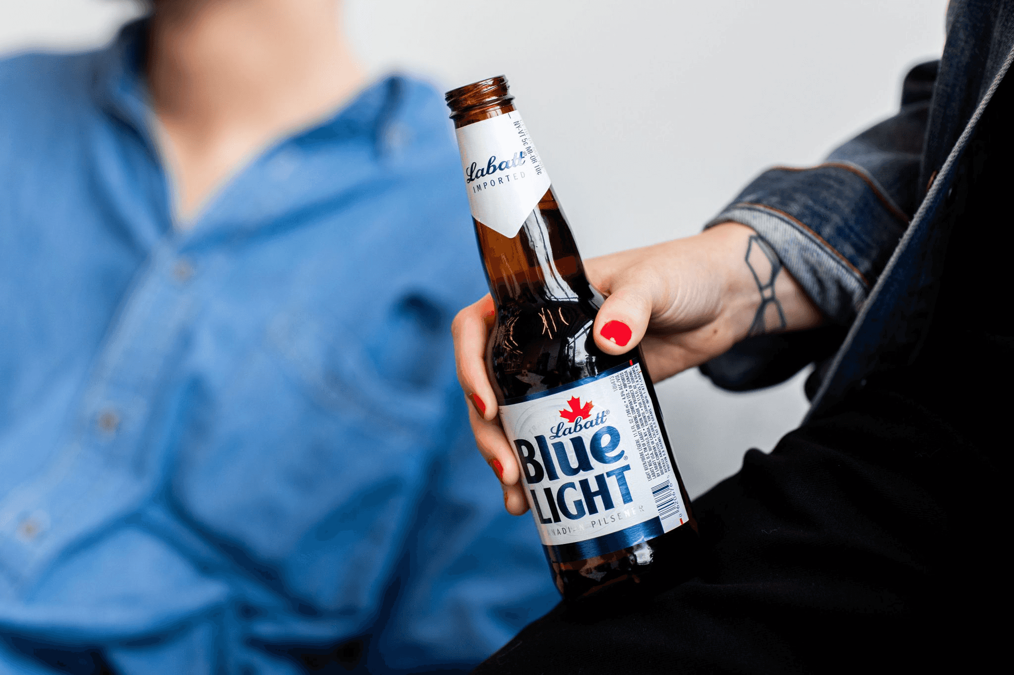 Photograph of a hand holding a bottle of Labatt Blue Light
